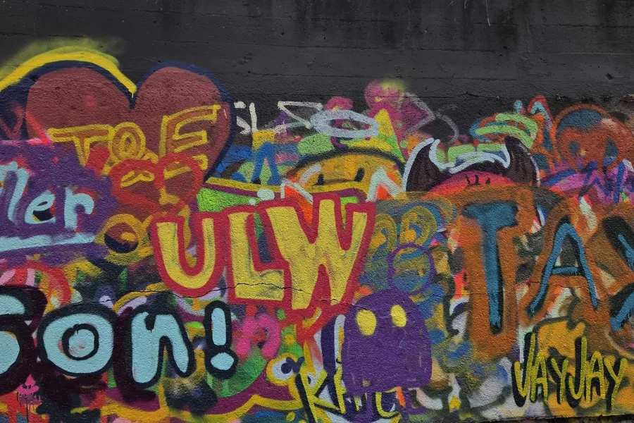 concrete wall of colorful graffiti with a focus on ULW